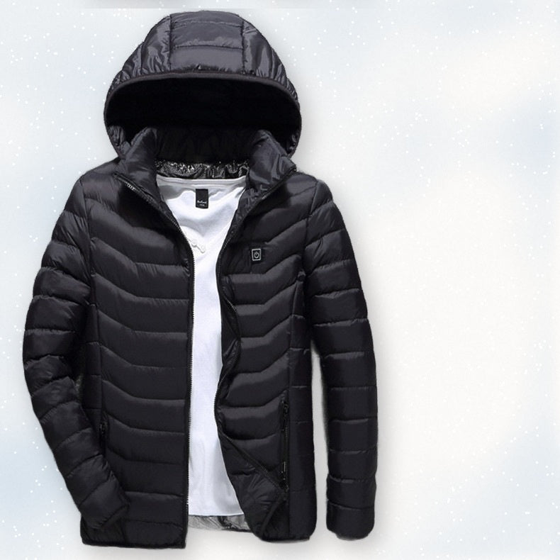 Black USB heated jacket with hood laid on fresh snow, front view