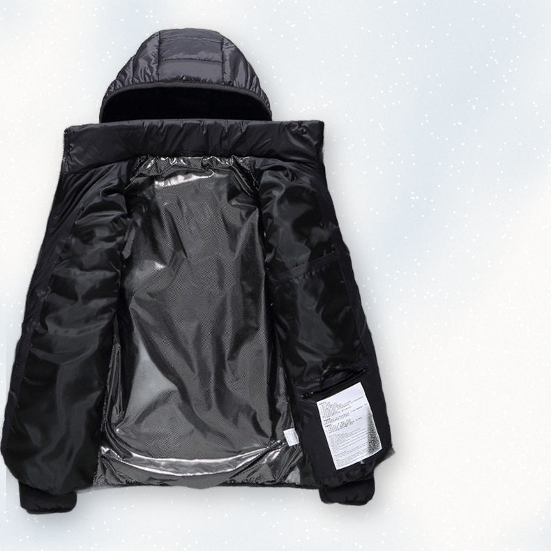 Black USB heated jacket laid open on snow showing the metallic heat-reflective lining
